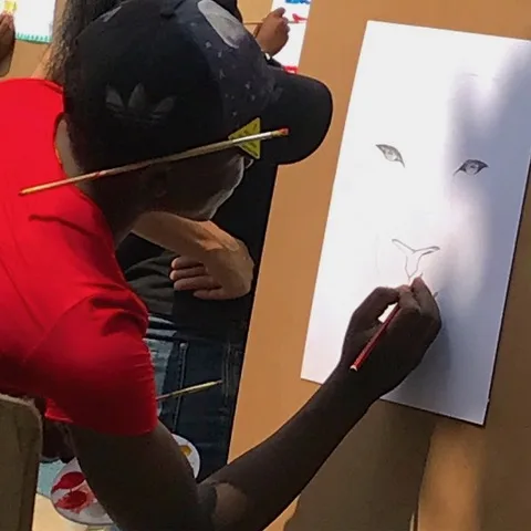 A heART learner sketching a lion at an easel
