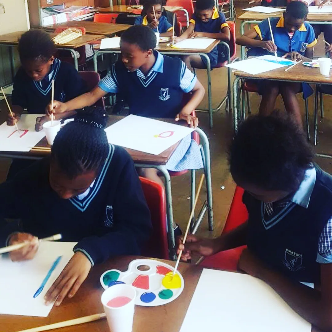 Learners painting at their desks