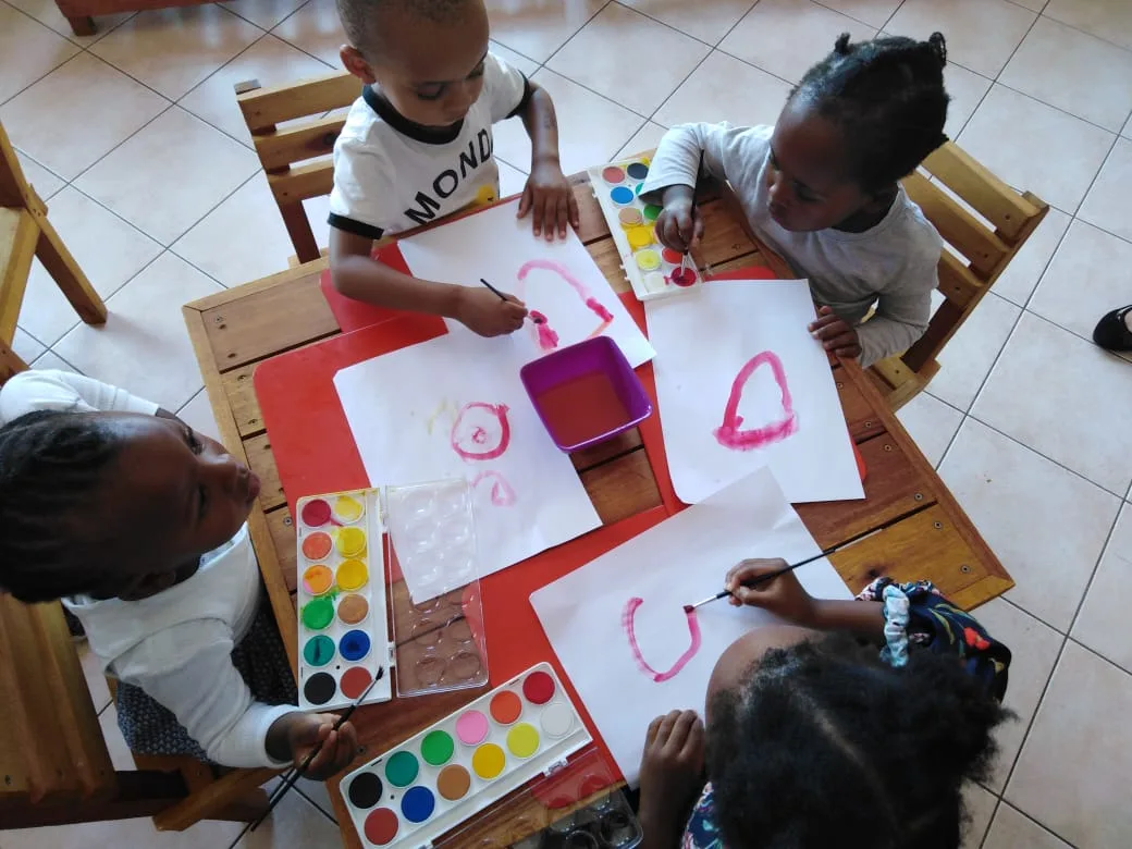 Young children painting at a shared table