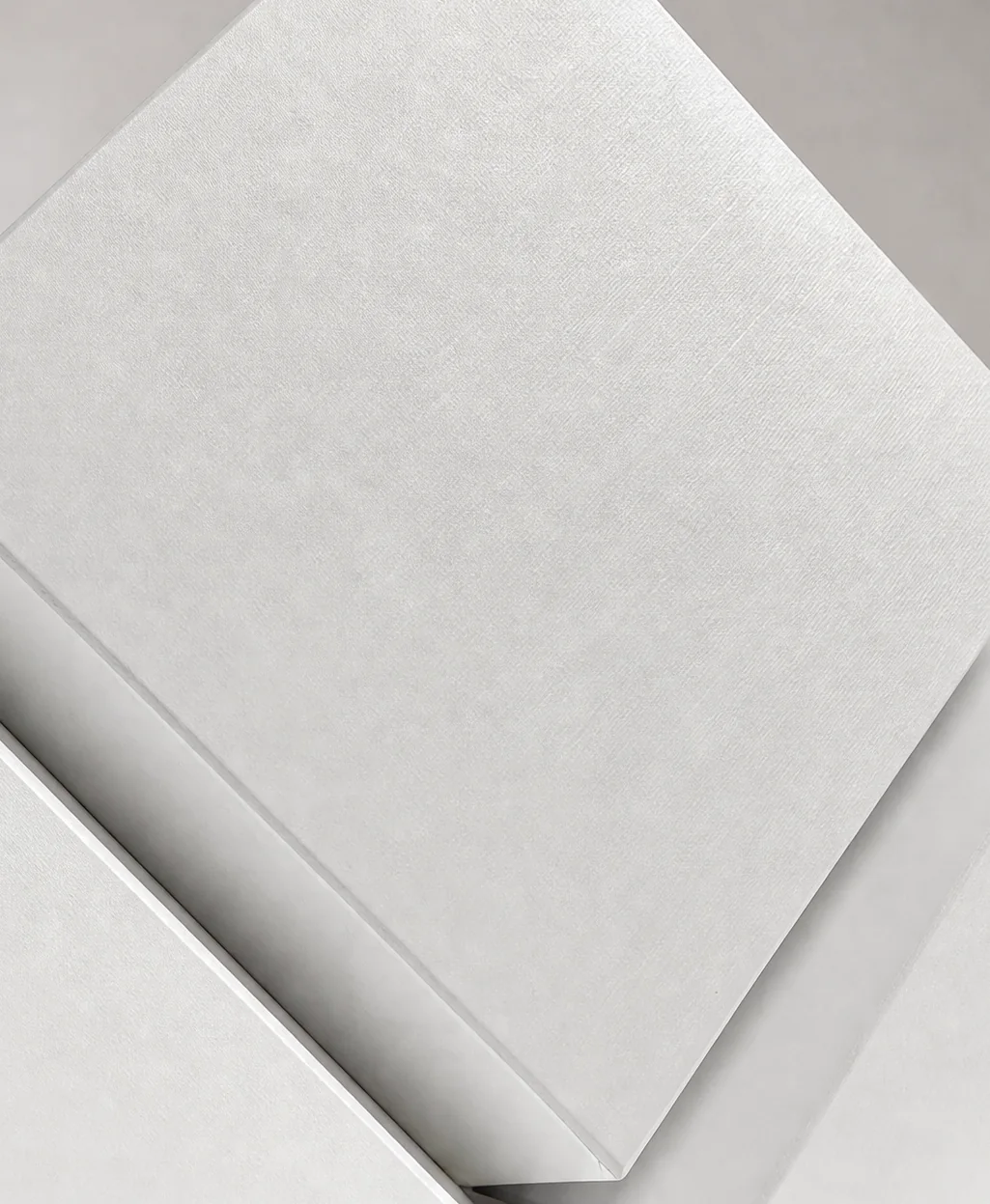 The textured white board and crisp folded edges, close up