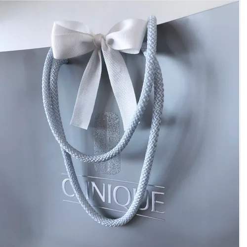 Clinique carrier bag in silver grey with rope handles and a white ribbon bow